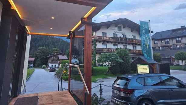 The entrance of Die Hotel Pension with a covered outdoor area and a view of the surrounding buildings and street. - No1 - Flo's modern Rooms & Breakfast  (Wagrain)