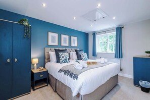 A bedroom with a bed, bedside table, lamp, and a window with curtains. - NEW! Stunning Home, Ideal for Groups, FREE Parking (Chester)