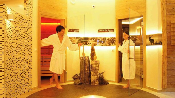 Sauna, jossa on puuseinät ja lasiovi. Oviin on merkitty tekstit ”Lempeä sauna” ja ”Suomalainen sauna”.