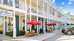 A beachfront hotel with a balcony, outdoor seating, and a sign for 'Chef's'.