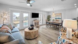 A spacious living room with a sofa, a round coffee table, and a dining area with a table and chairs.