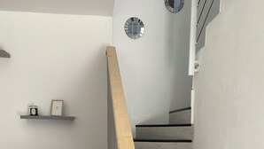A modern staircase with wooden steps and a wooden handrail, leading to an upper floor. - Maison en Pierre (Ploumagoar)