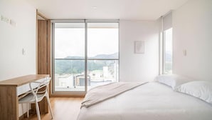 A bedroom with a bed, a desk, and a chair. - Uhaus 704 (Manizales)