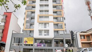 A multi-story building with a modern architectural design, featuring a mix of glass and concrete facades, and a prominent entrance with a ramp. - Uhaus 704 (Manizales)
