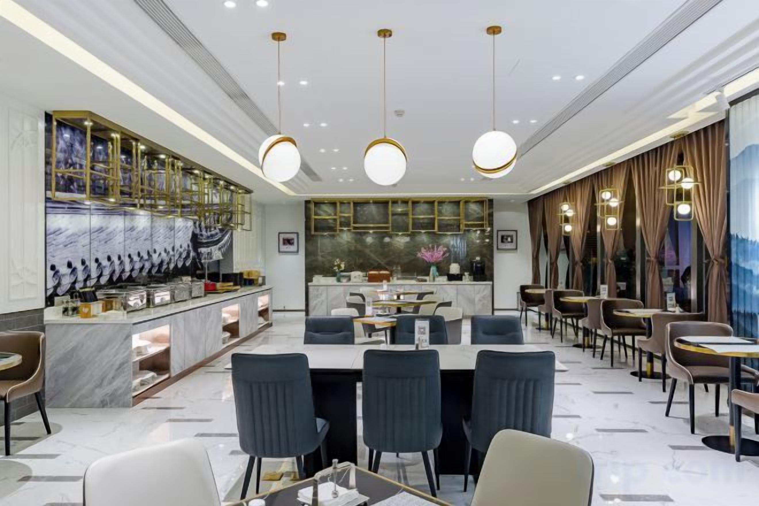 A modern restaurant interior with a bar area, seating, and a decorative wall.