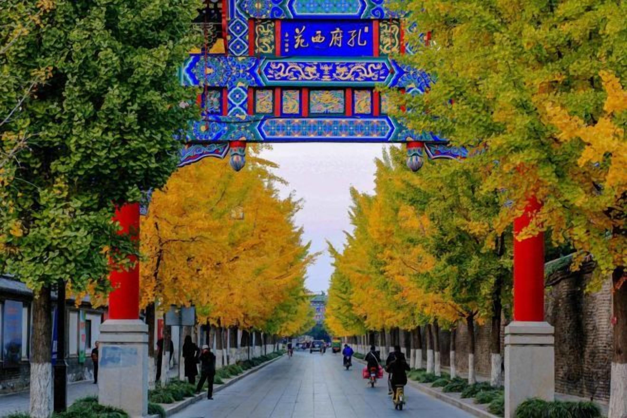 A tree-lined street with a traditional archway.