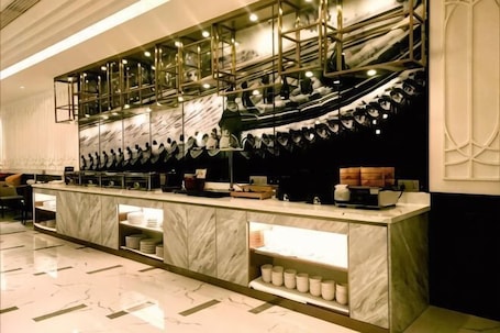 Un espace bar moderne doté d’un comptoir en marbre, d’un éclairage suspendu et d’un mur orné de motifs.. Magnotel Hotel (Qufu Sankong Scenic Area Chunqiu West Road)
