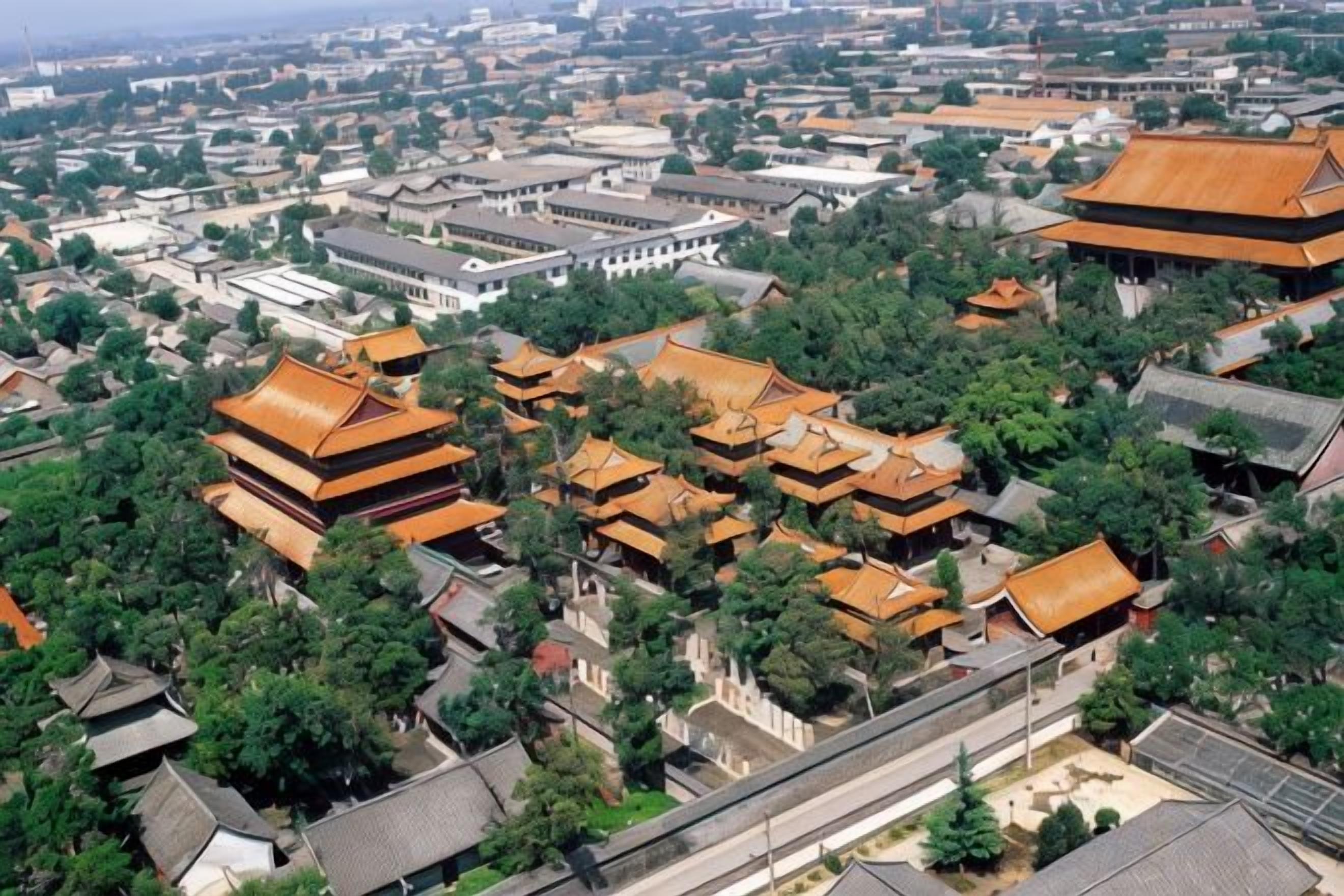 Un complesso architettonico cinese tradizionale con diversi edifici, tra cui strutture in stile pagoda e un ampio edificio bianco.