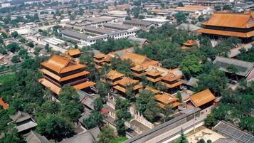 Un complesso architettonico cinese tradizionale con diversi edifici, tra cui strutture in stile pagoda e un ampio edificio bianco.