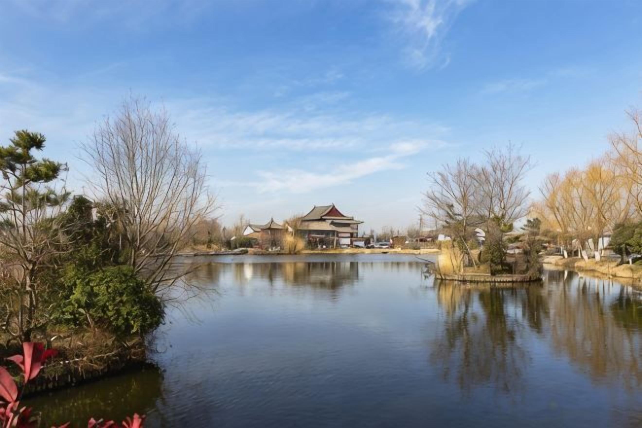 A serene lakeside setting with a traditional building, reflecting in the calm water.