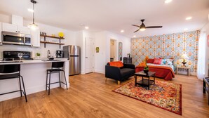 A modern apartment with a kitchen, dining area, and a bedroom.