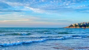 A coastal view with waves approaching a rocky shore with buildings. - Jinjiang Inn (Weihai Liugong Island Scenic Area Weigao Square Branch) (Weihai)