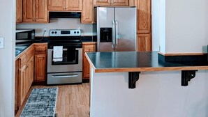A kitchen with wooden cabinets, stainless steel appliances, and a black countertop. - Heaths Cove on Lake Murray with 3 bed 3 baths. Beautiful lake views and dock (Prosperity)