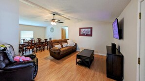 A living room with a brown sofa, a black leather chair, a coffee table, and a TV on a stand. - Heaths Cove on Lake Murray with 3 bed 3 baths. Beautiful lake views and dock (Prosperity)
