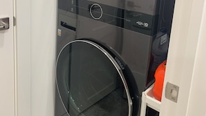 Une petite buanderie moderne équipée de deux machines à laver superposées.
