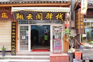 En traditionel japansk butik med et skilt, indgang og krukker med planter.