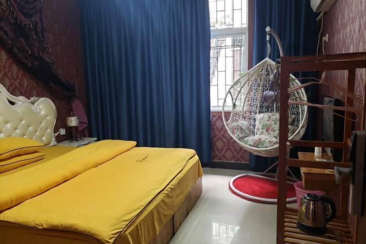 A bedroom with a bed, a hanging chair, a wooden shelf, and a window with bars.