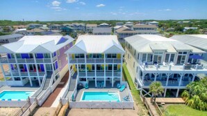 Un hôtel situé sur la côte, composé de plusieurs bâtiments, chacun doté de balcons et d’un espace piscine.