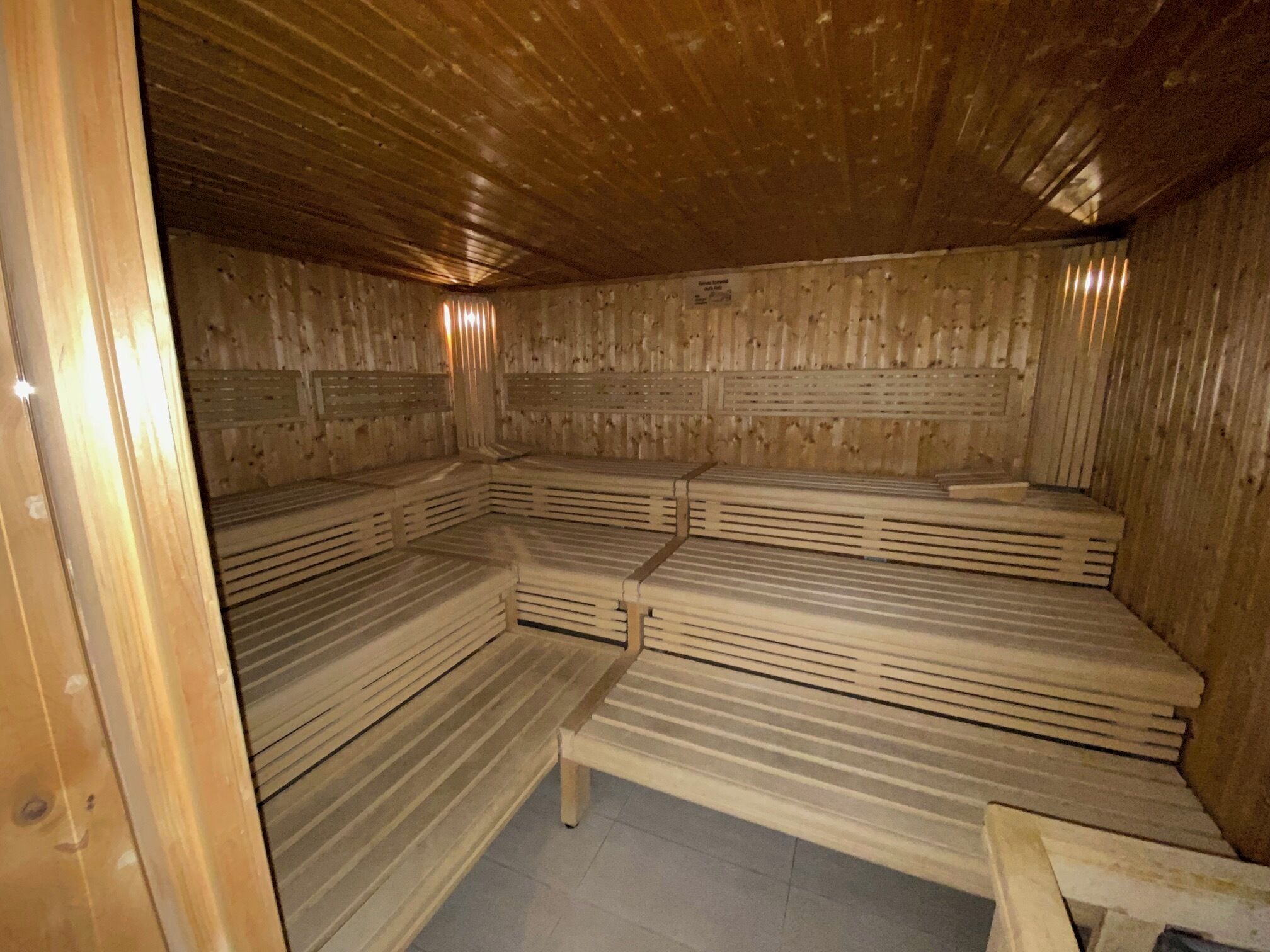 En sauna med træbænke og skrå vægge.