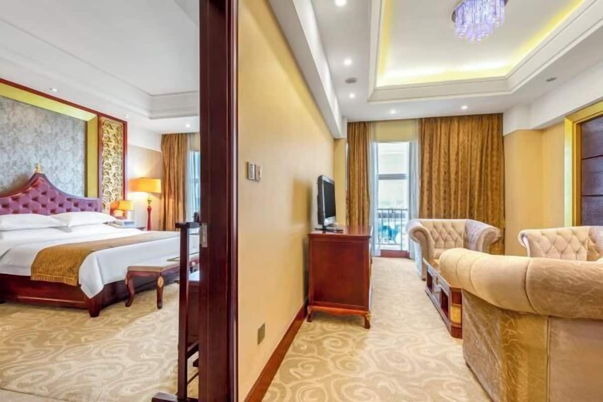 Une chambre d’hôtel avec un grand lit, un canapé, une télévision et une vue sur l’extérieur.