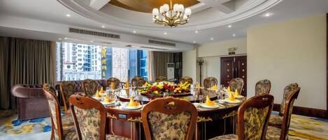 A dining room with a round table, chairs, and a chandelier.