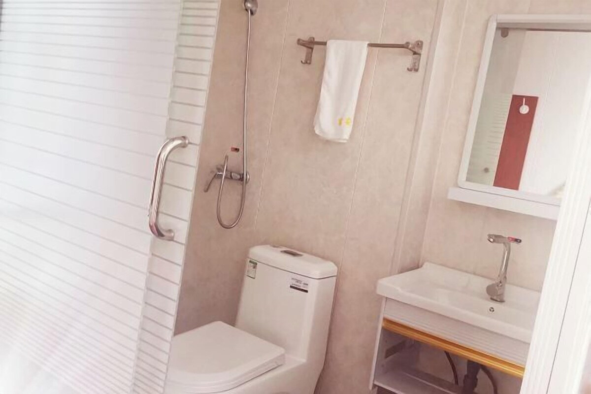 A bathroom with a toilet, a sink, and a shower.