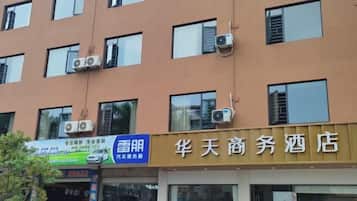 A hotel with multiple windows and air conditioning units on the exterior wall.