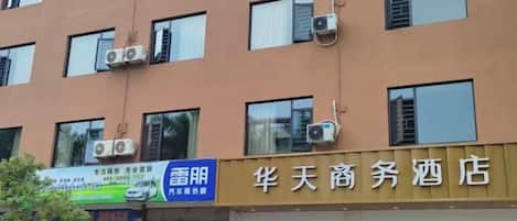 Un hotel con múltiples ventanas y unidades de aire acondicionado en la pared exterior.