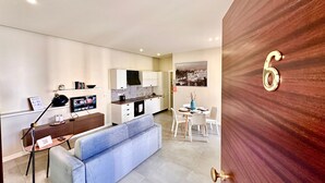 Un apartamento moderno con kitchenette, comedor, sofá y una puerta de madera con el número 6.