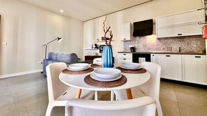 Una cocina moderna con armarios blancos, horno integrado y salpicadero de azulejos.