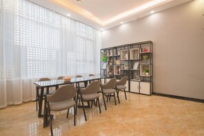 A conference room with a long table, chairs, and a bookshelf. - Penglai Hotel (Shenzhen)