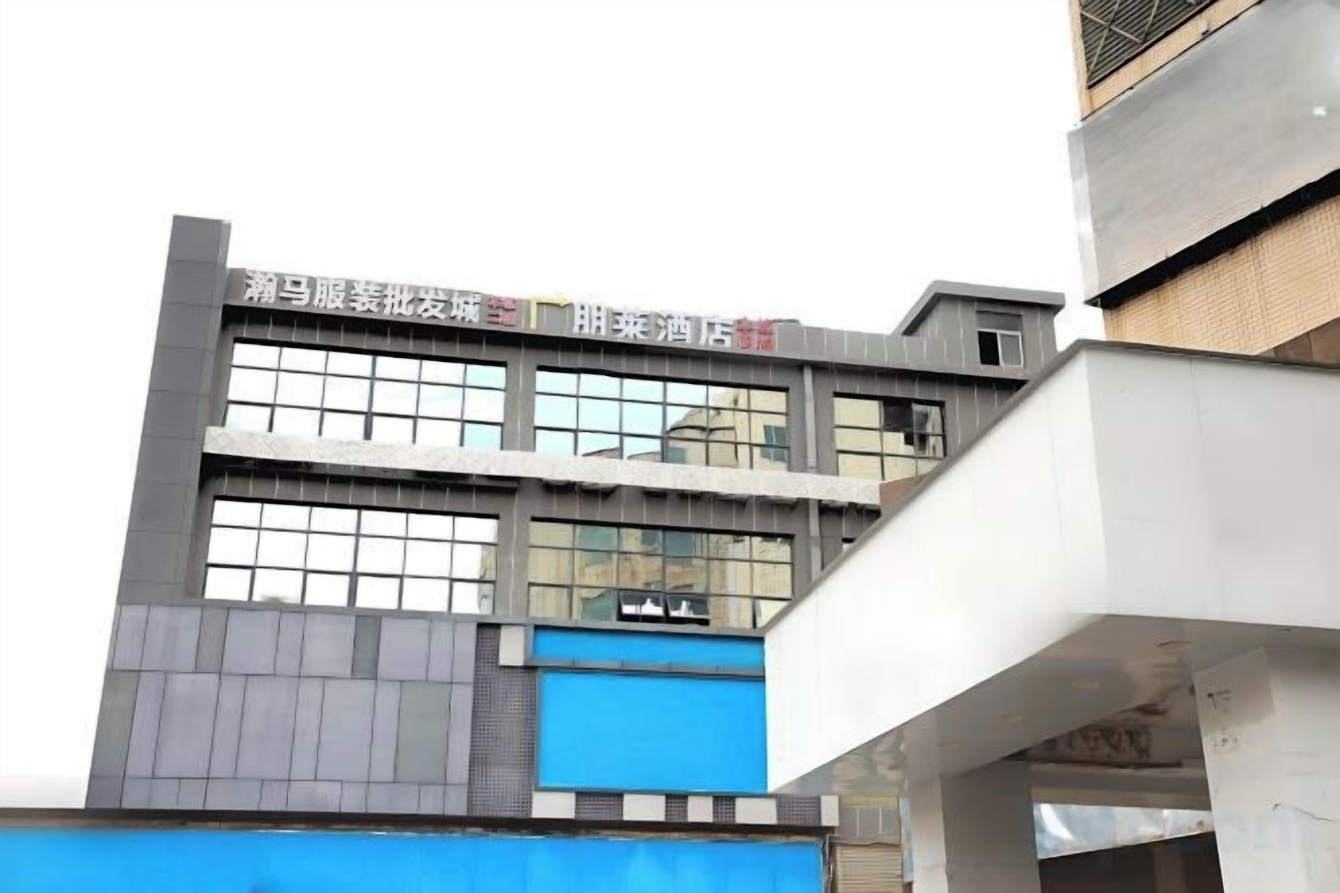 A multi-story building with a flat facade, large windows, and signage indicating various businesses.