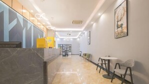 A hotel lobby with a marble reception desk, a reception area, and a seating area with tables and chairs. - Penglai Hotel (Shenzhen)