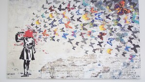 A wall with a mural of a woman and butterflies. - Hotel Rafay (Blackburn)