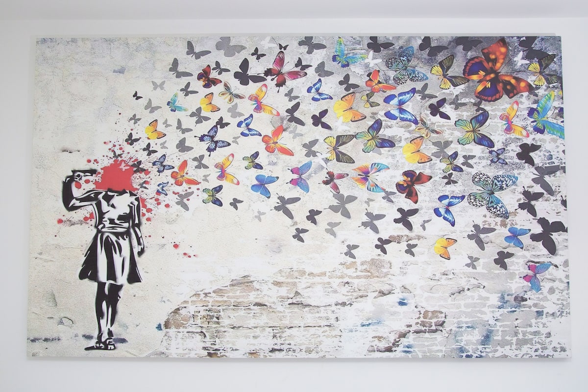 Pared con un mural de una mujer y mariposas.
