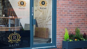 A hotel entrance with a glass door displaying the hotel's logo and name. - Hotel Rafay (Blackburn)