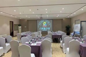 A conference room with rows of tables and chairs, a projector screen, and a presentation area. - Yijia 365 Chain Hotel (Shijiazhuang Canal Bridge Railway University Yitang Metro Station Branch) (Shijiazhuang)