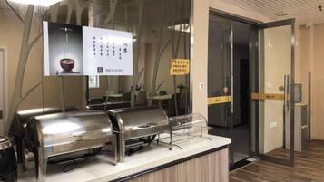 Una barra de restaurante con un tablero de menú, una caja registradora y un acceso por puerta de vidrio.