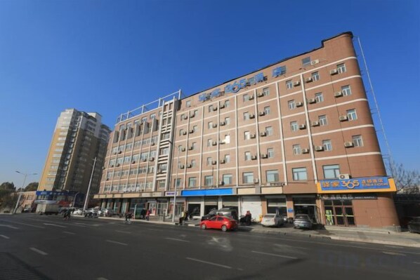 A multi-story building with a central entrance and several ground-level shops. - Yijia 365 Chain Hotel (Shijiazhuang Canal Bridge Railway University Yitang Metro Station Branch) (Shijiazhuang)
