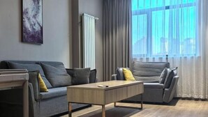 A modern living room with a grey sofa, a wooden coffee table, and a grey armchair. - Yijia 365 Chain Hotel (Shijiazhuang Canal Bridge Railway University Yitang Metro Station Branch) (Shijiazhuang)