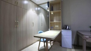 A compact kitchen with wooden cabinets, a small dining table, a built-in dishwasher, and a pendant light. - Yijia 365 Chain Hotel (Shijiazhuang Canal Bridge Railway University Yitang Metro Station Branch) (Shijiazhuang)