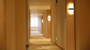 Un couloir d'hôtel avec des revêtements de sol en moquette et des luminaires fixés au mur.