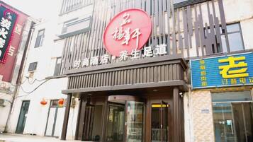 A building with a prominent red sign, a storefront with a blue sign, and a traditional architectural style.