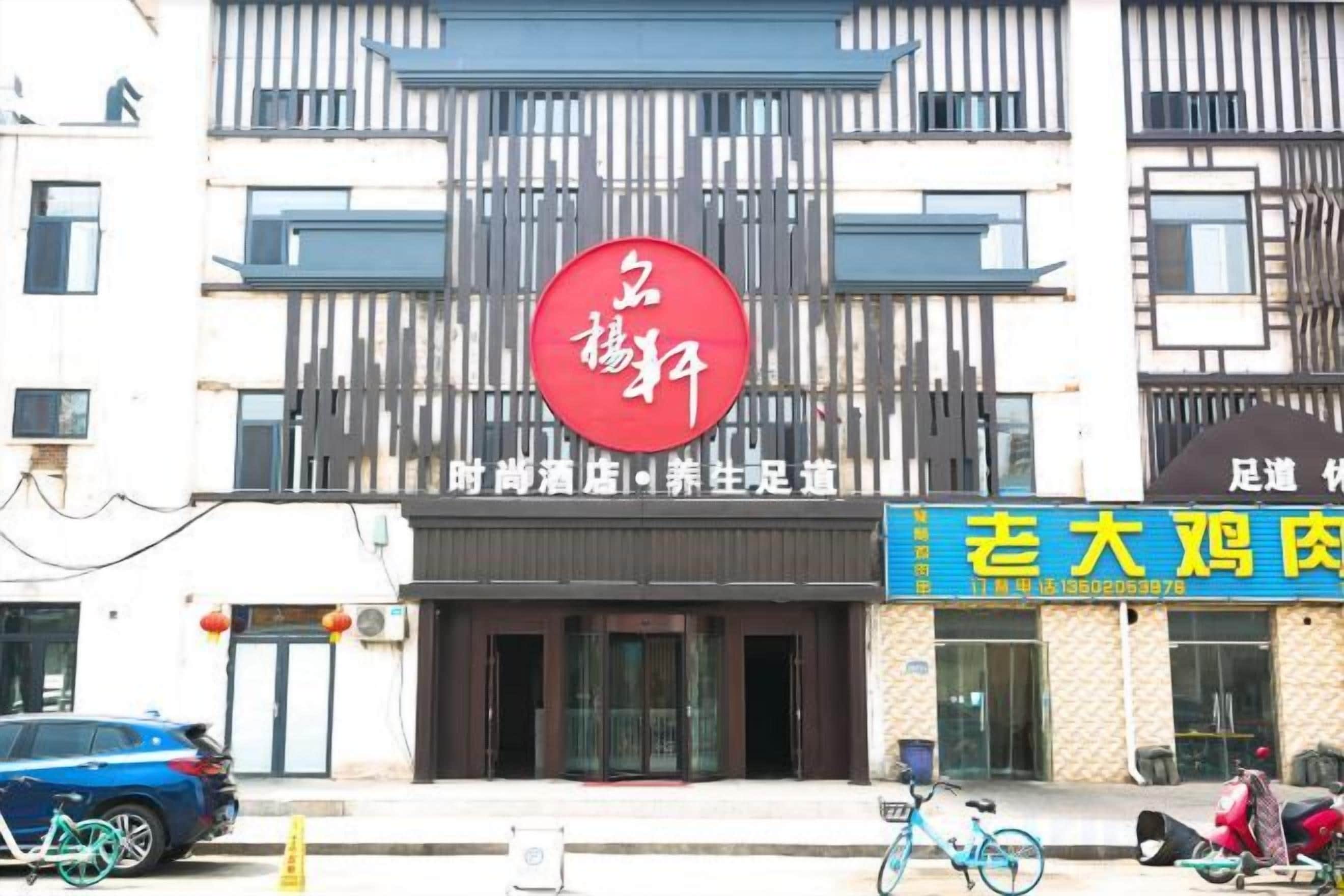 A building with a prominent red circular sign, a blue storefront with yellow lettering, and a parked bicycle.