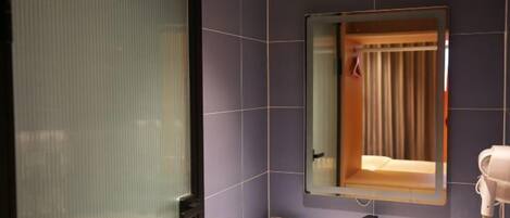 Un baño con espejo, secador de pelo y lavabo.