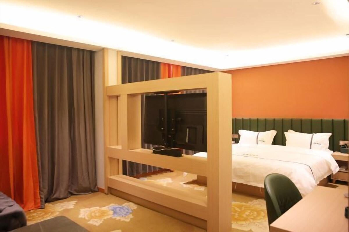 A hotel room with a bunk bed, a desk, and a chair.