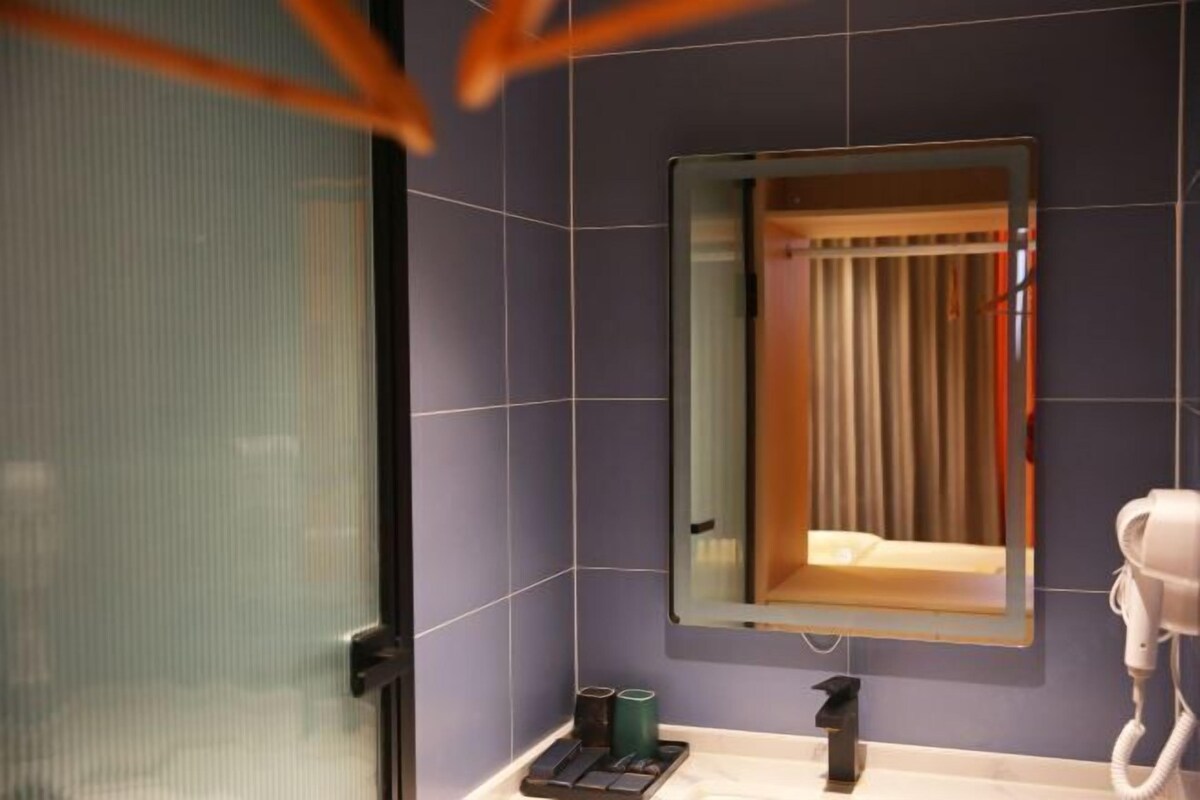 A bathroom with a mirror, a sink, and a hairdryer.