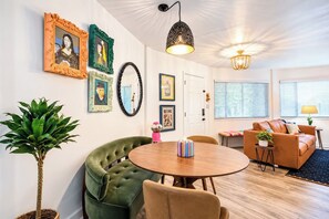 A modern living room with a round wooden table, green armchairs, a sofa, and a potted plant. - The Hutt, Walk to Campus, by VelvetDitchVillas (Oxford)