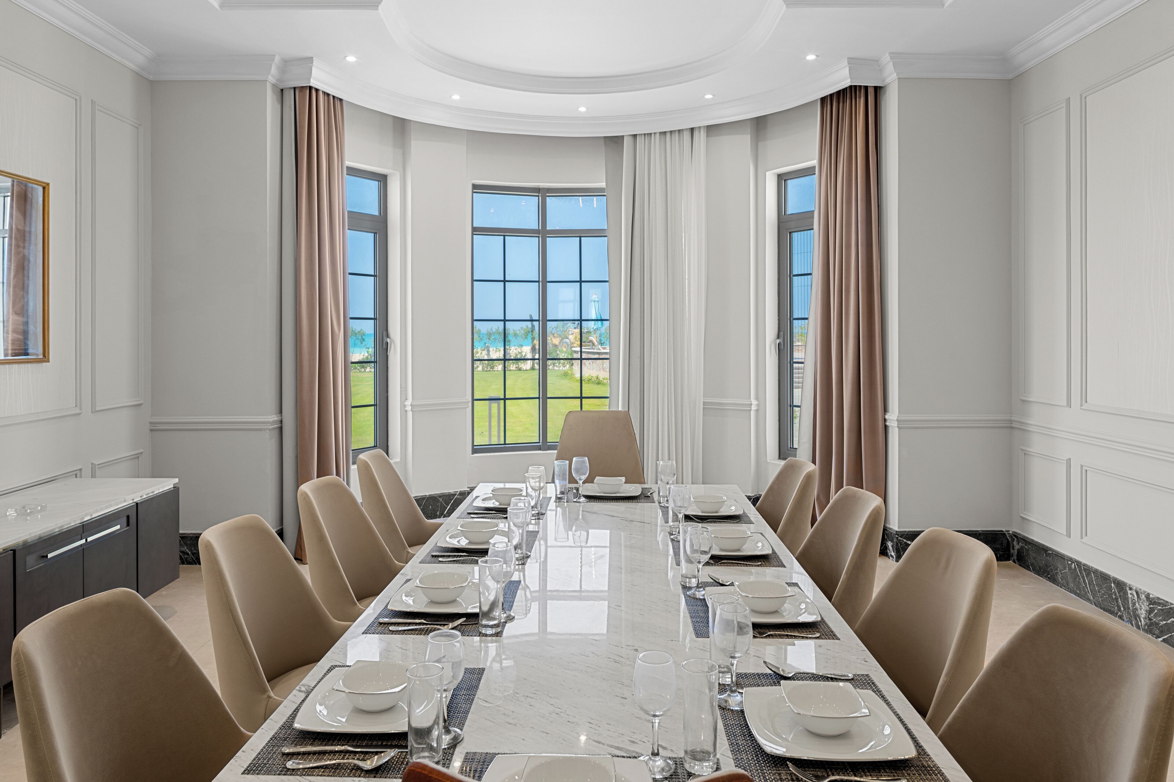 A conference room with a long table, chairs, and a view of the outdoors.