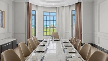 A conference room with a long table, chairs, and a view of the outdoors.